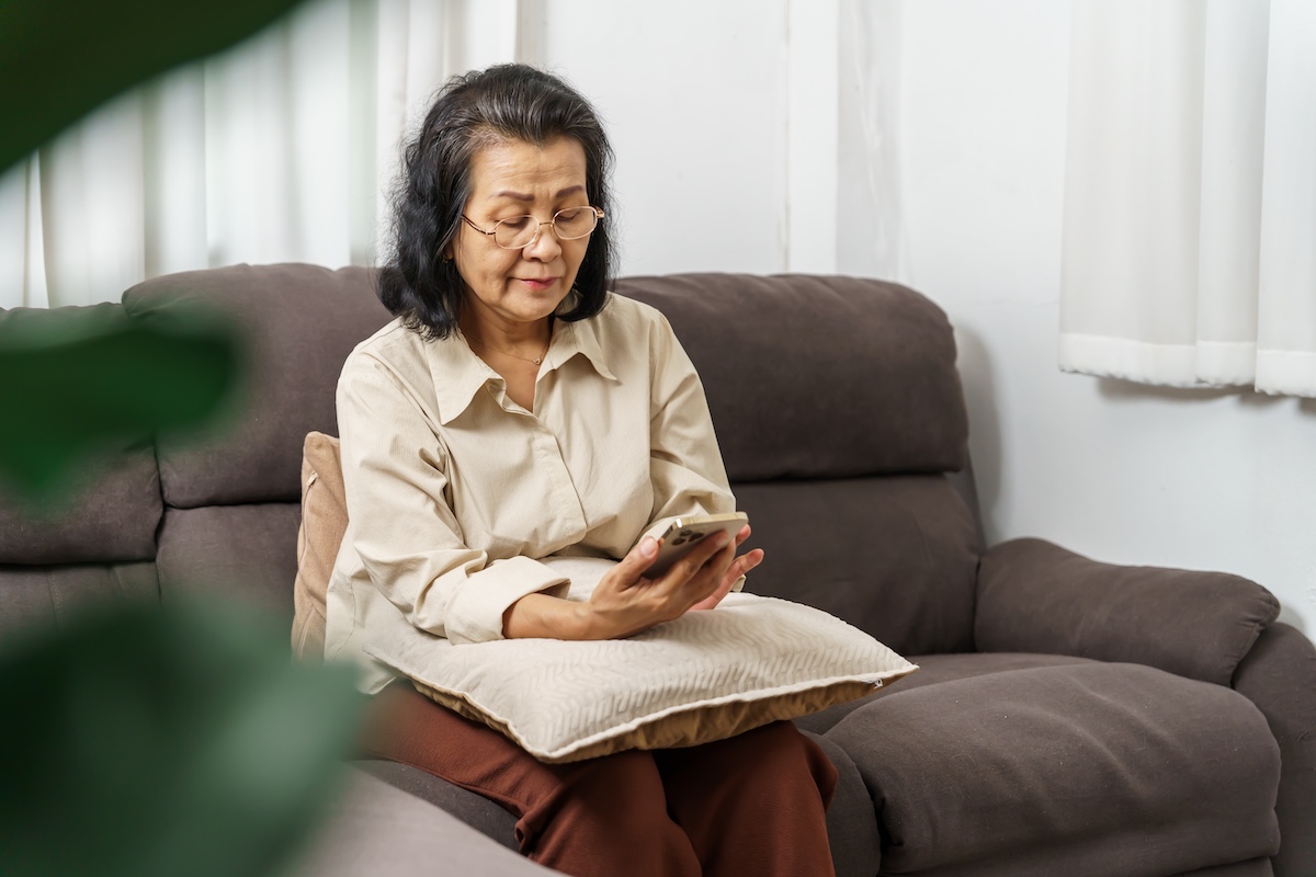 woman resting her phone on a pillow while